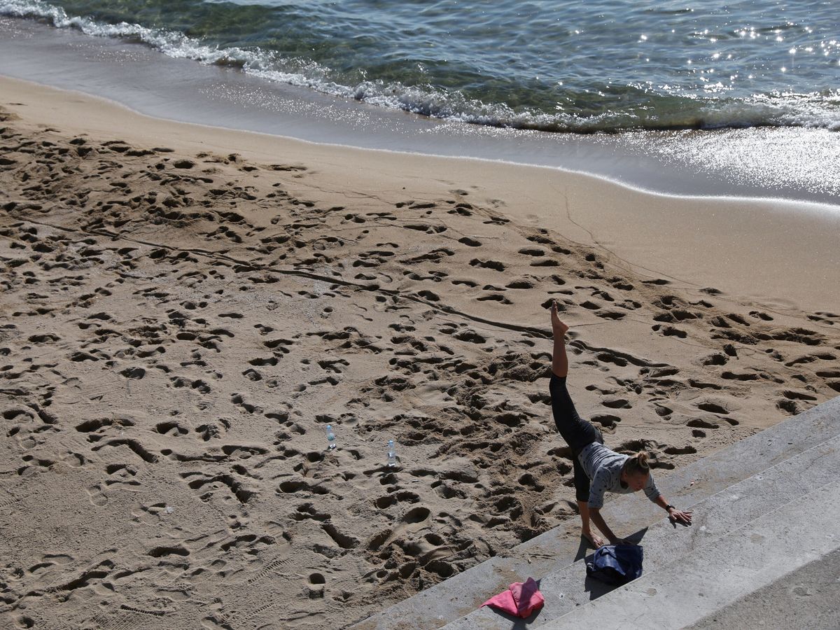 Foto: Una mujer hace ejercicio en la Barceloneta, ayer. (Reuters)