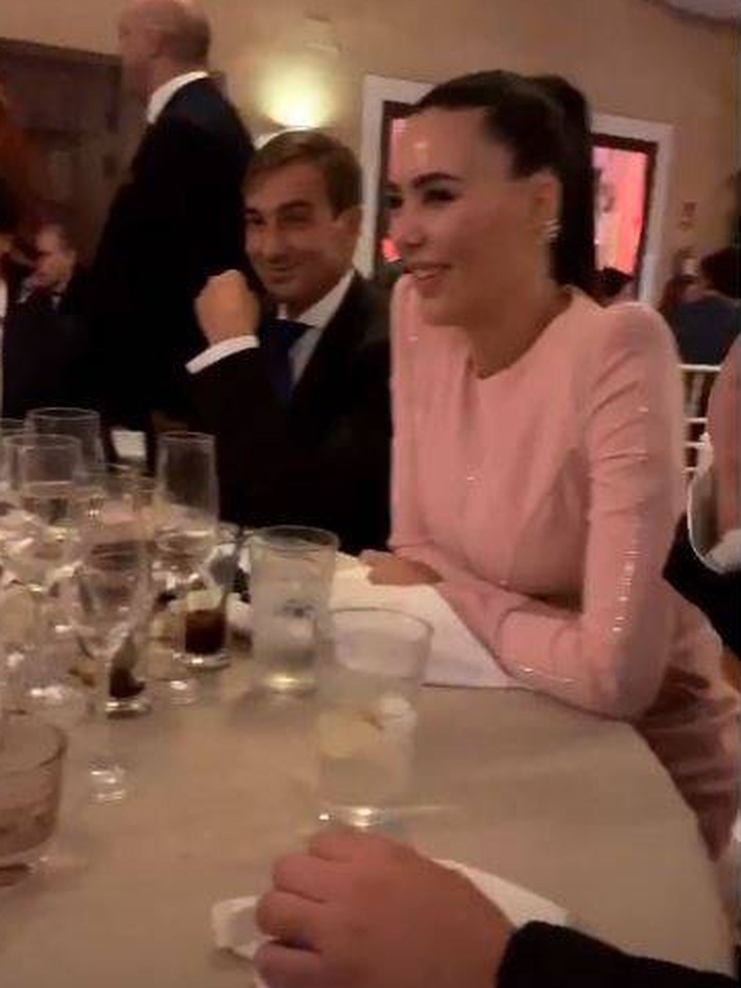 Vania Millán, muy guapa de rosa y sentada en una de las mesas del banquete. (Redes)