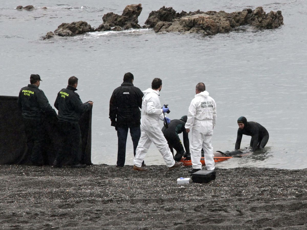 Foto: La Guardia Civil recoge a uno de los inmigrantes que fallecieron en el intento de pasar a España. (EFE)