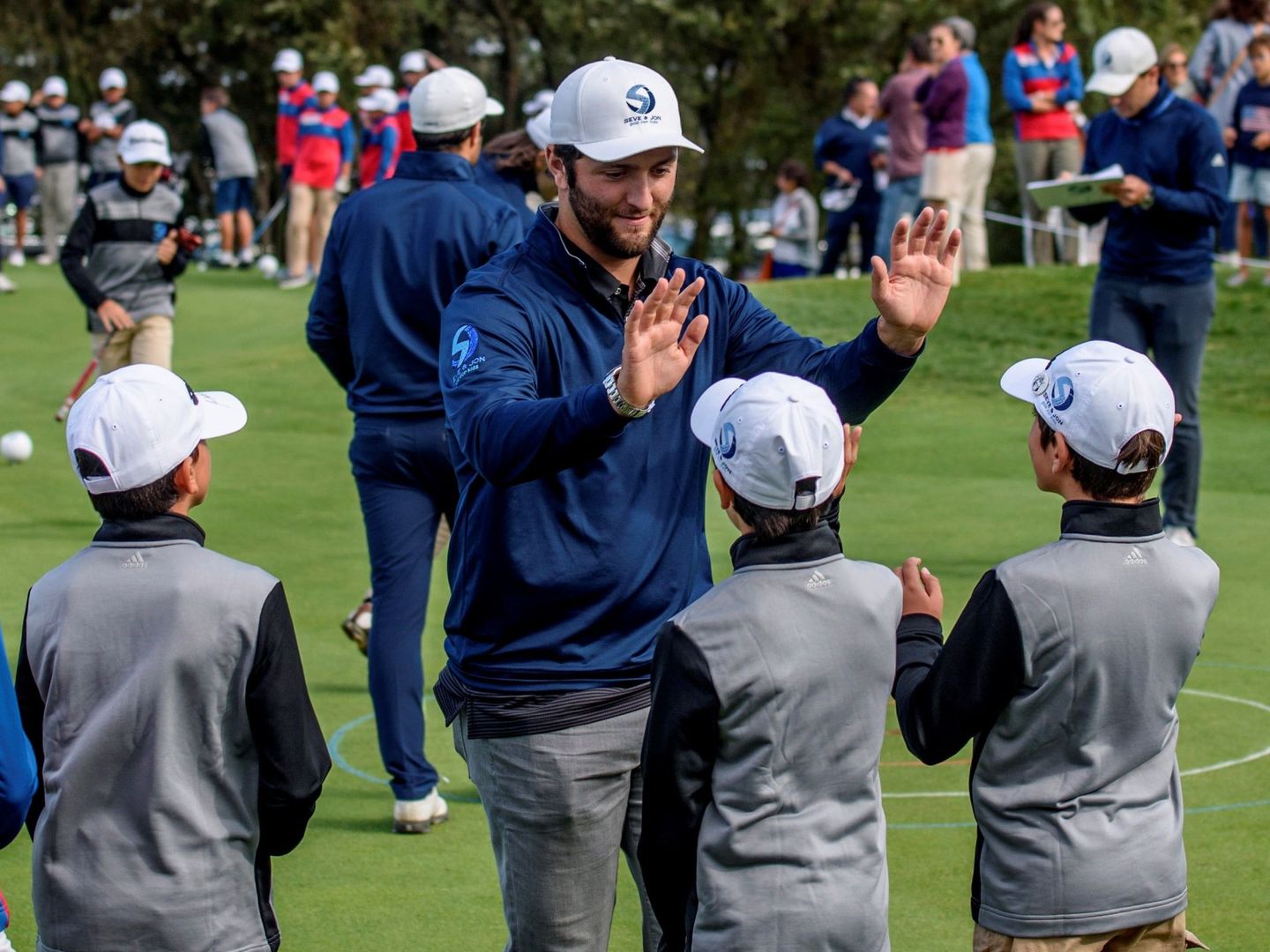 Jon Rahm felicita a unos niños en el marco del torneo Seve & Jon Golf for Kids. (EFE)