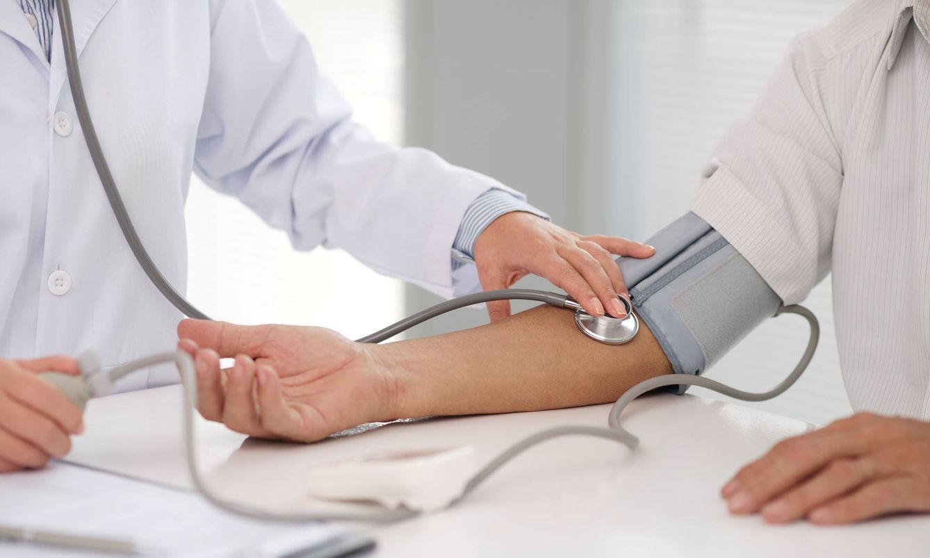 Un médico mide la tensión a un paciente para comprobar si tiene la presión arterial alta. (iStock)