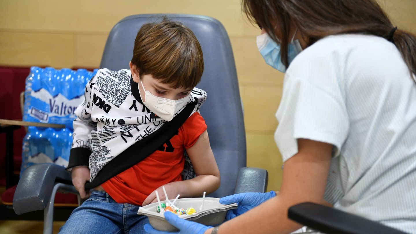 Una enfermera ofrece caramelos a un niño tras administrarle la vacuna contra el covid. (EFE)