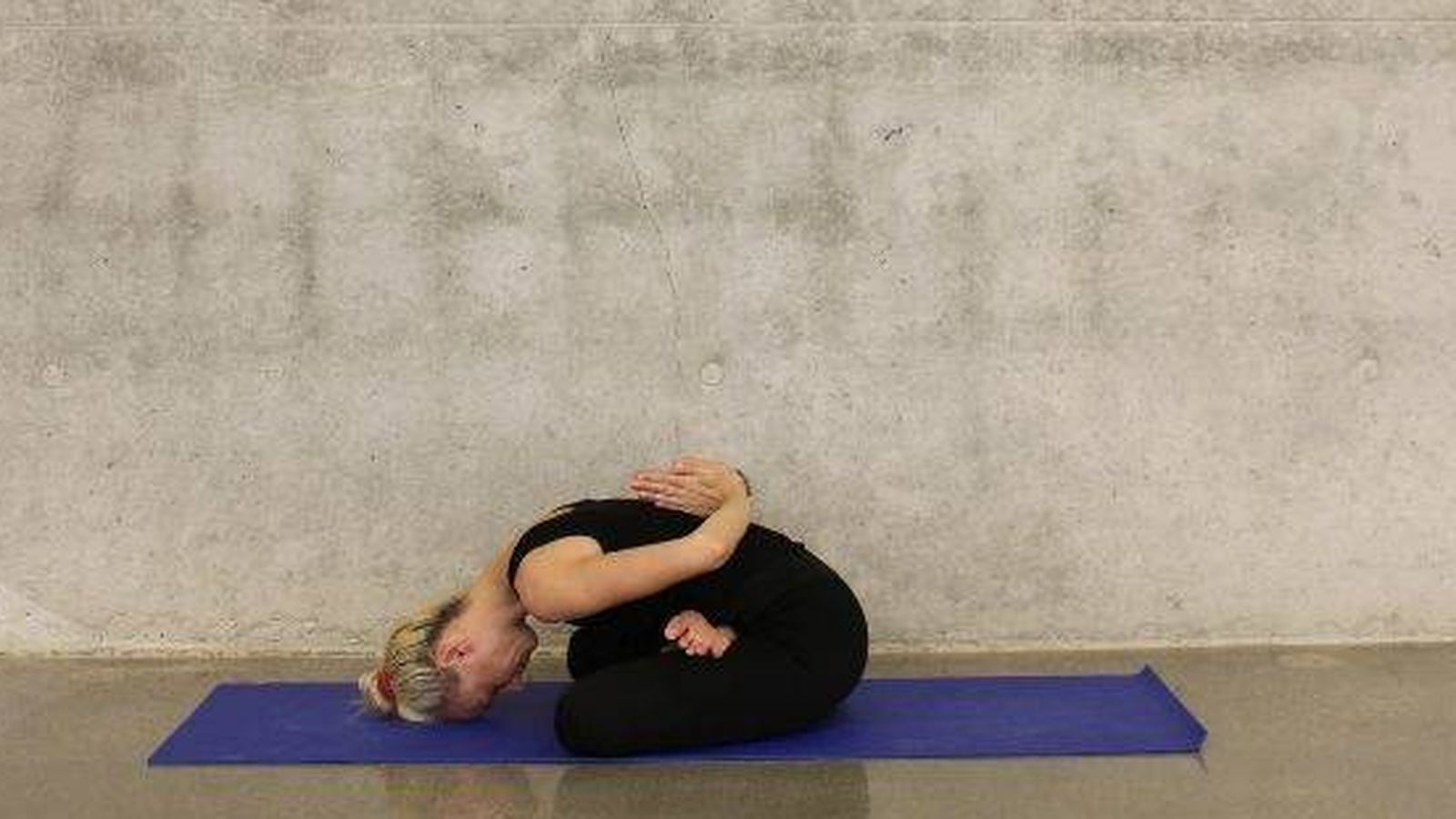 Foto: Mujer estirando sobre esterilla de yoga (Foto: Unsplash)
