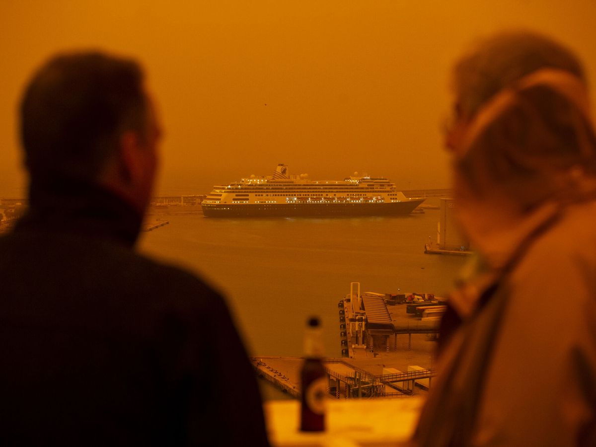 Foto: Dos personas observan el mar en una terraza este jueves, en donde Melilla y el sureste peninsular se han visto afectadas por el efecto de la calima. (EFE/ Daniel Pérez)