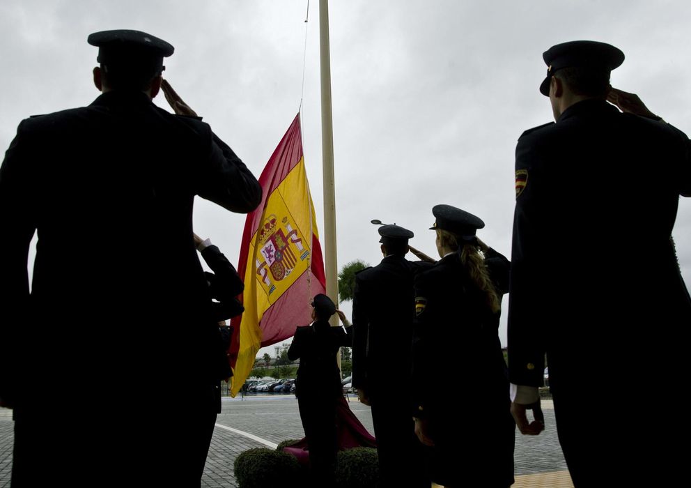 Foto: Agentes de la Policía Nacional izan la bandera española. (EFE)