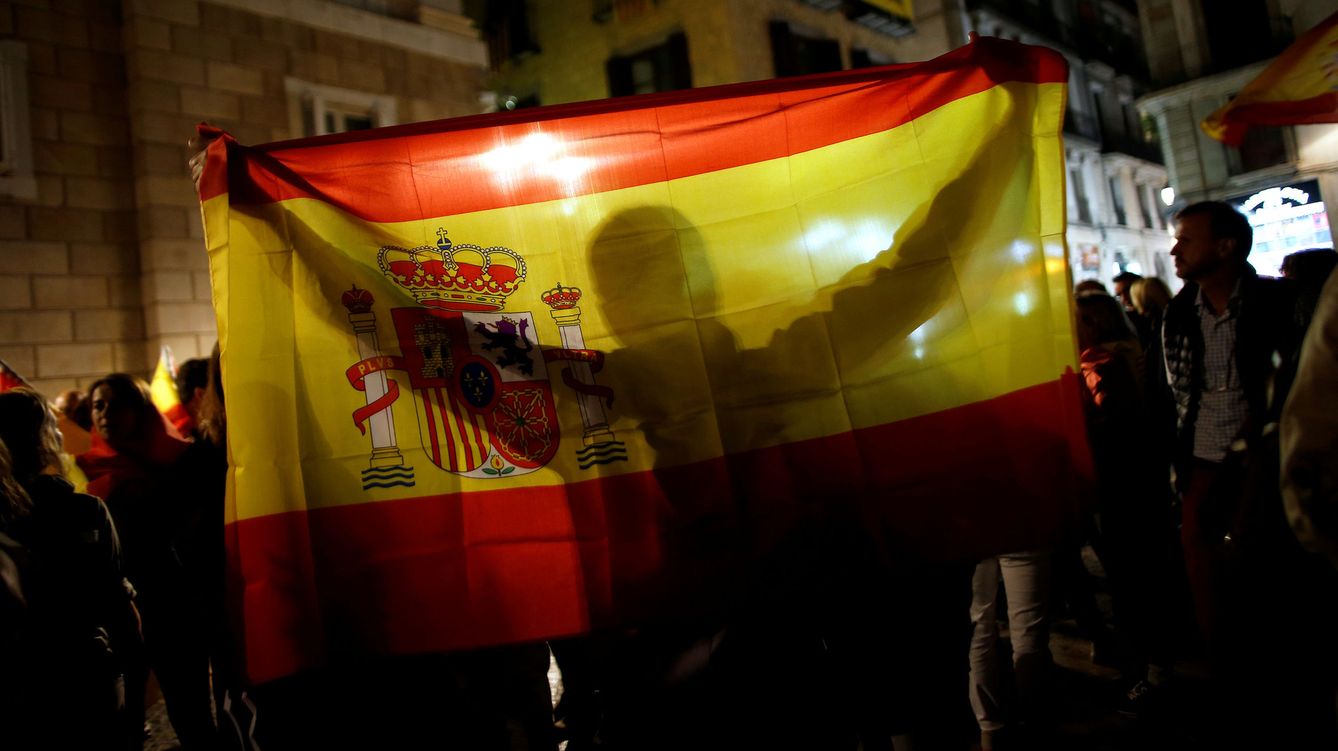 Foto: Una persona sostiene una bandera de España frente al Palau de la Generalitat. (Reuters)