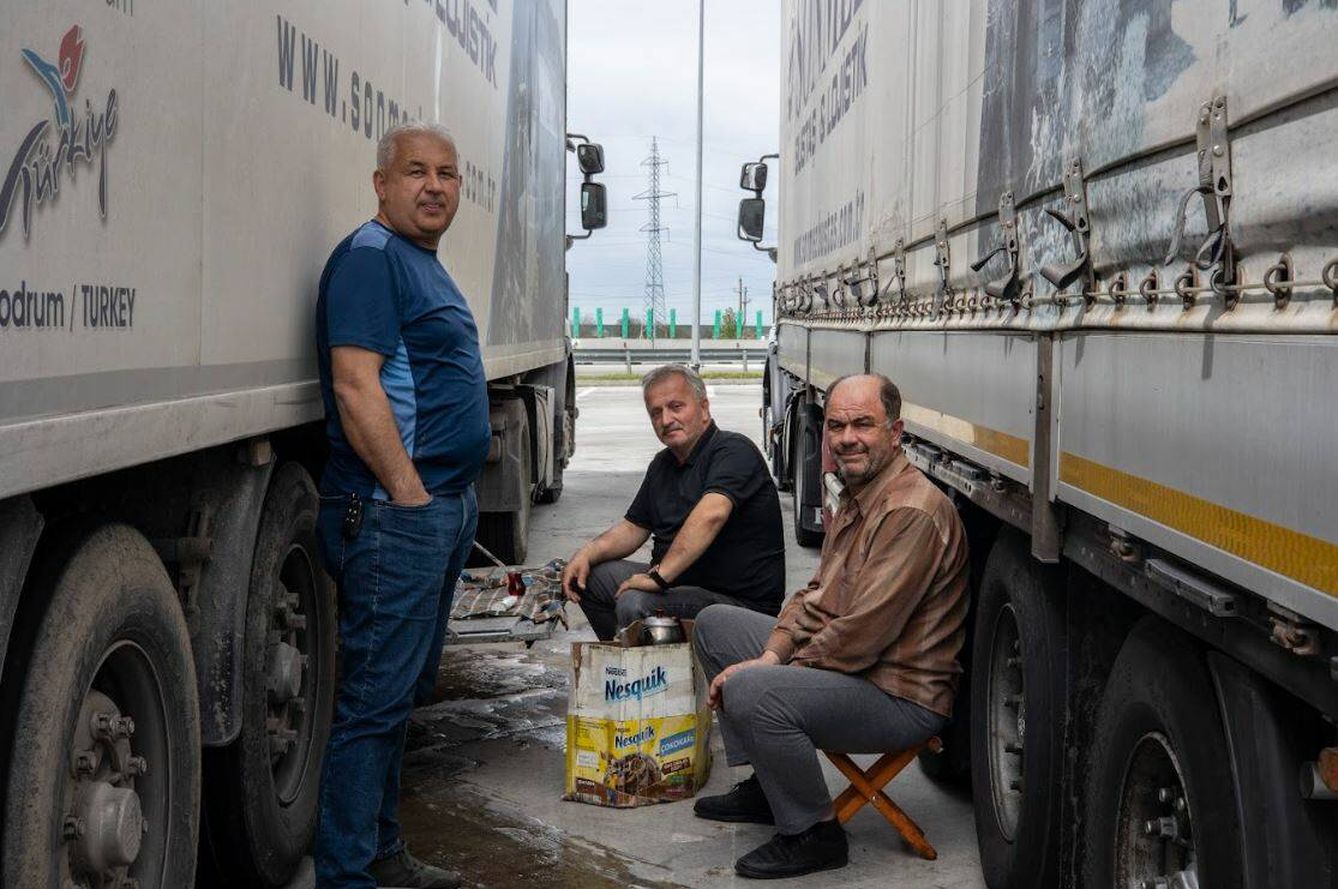 Los camioneros turcos Adnam y Saban, que transportan piezas de automóvil desde Turquía a Francia y Holanda, descansan a la sombra de su camión cerca de la frontera entre Rumanía y Bulgaria, el pasado 4 de abril. (Lola García-Ajofrín/El Confidencial/PULSE)