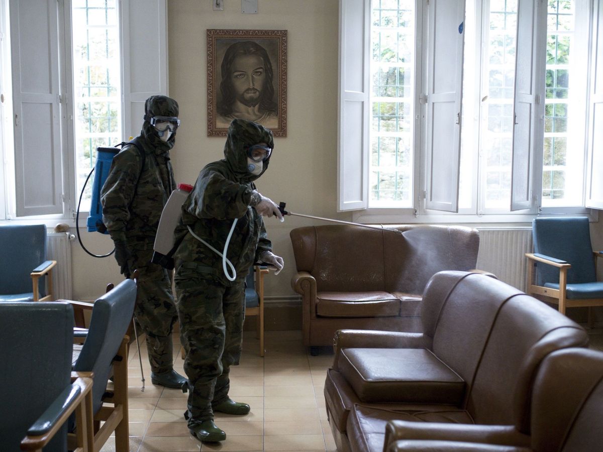 Foto: Un grupo de militares desinfectan una residencia. (EFE)