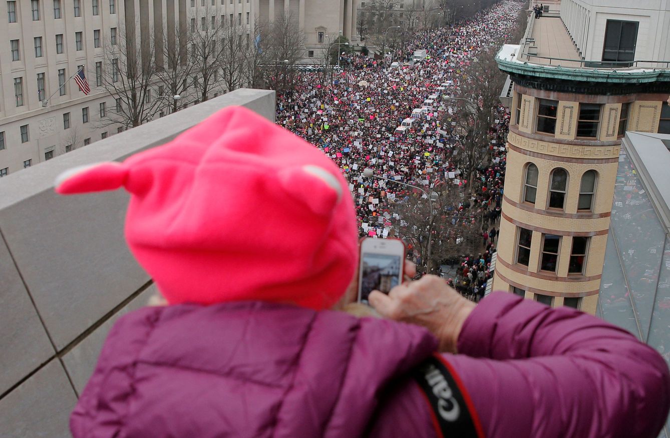 Una mujer fotografía la manifestación desde una terraza. (Reuters)