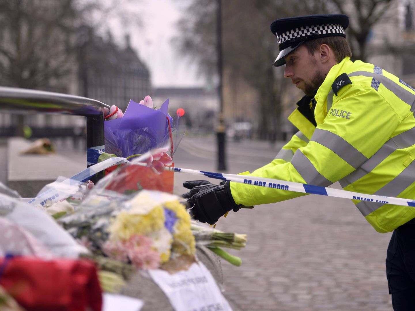 Un agente de policía ante un tributo floral a las víctimas del atentado, en Londres. (Reuters).