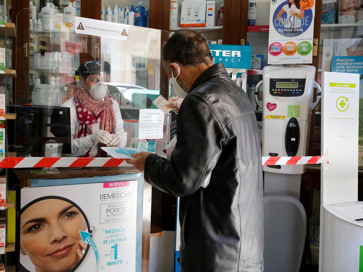 Foto: Un hombre recoge una mascarilla gratuita en una farmacia de Melilla. (EFE)