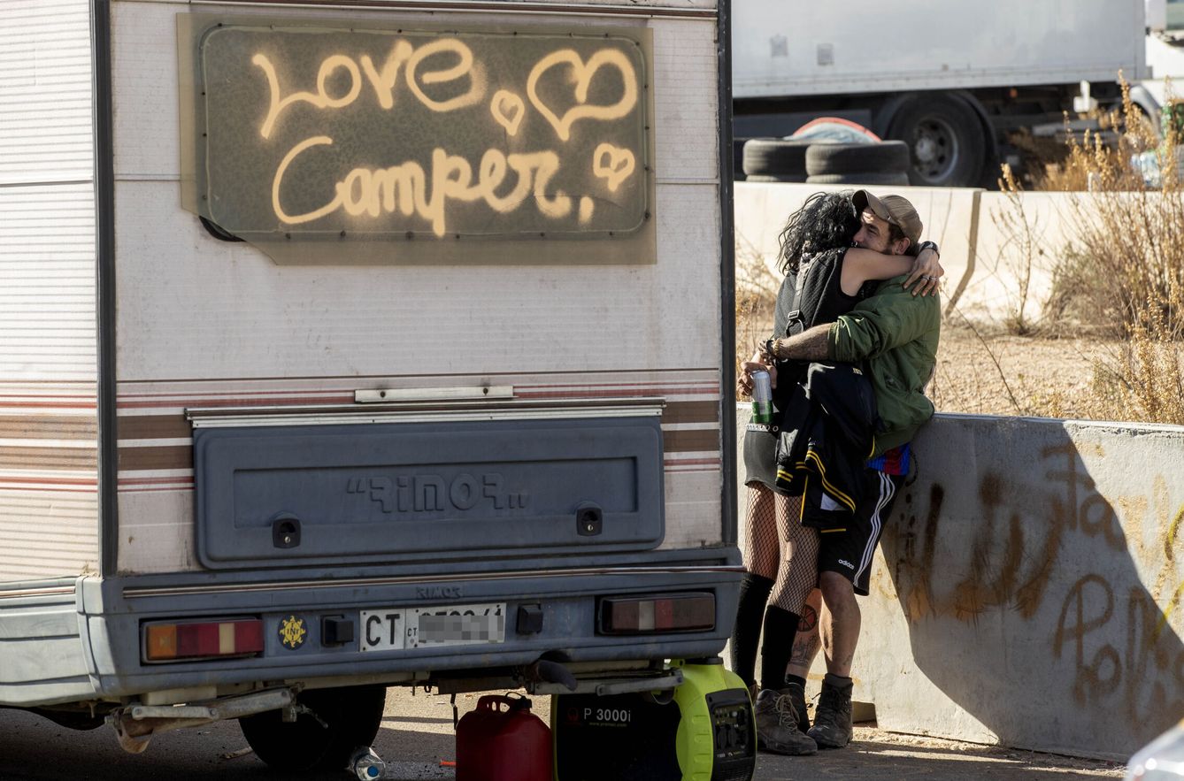 Una pareja, abrazada junto a su caravana en la rave. (EFE)