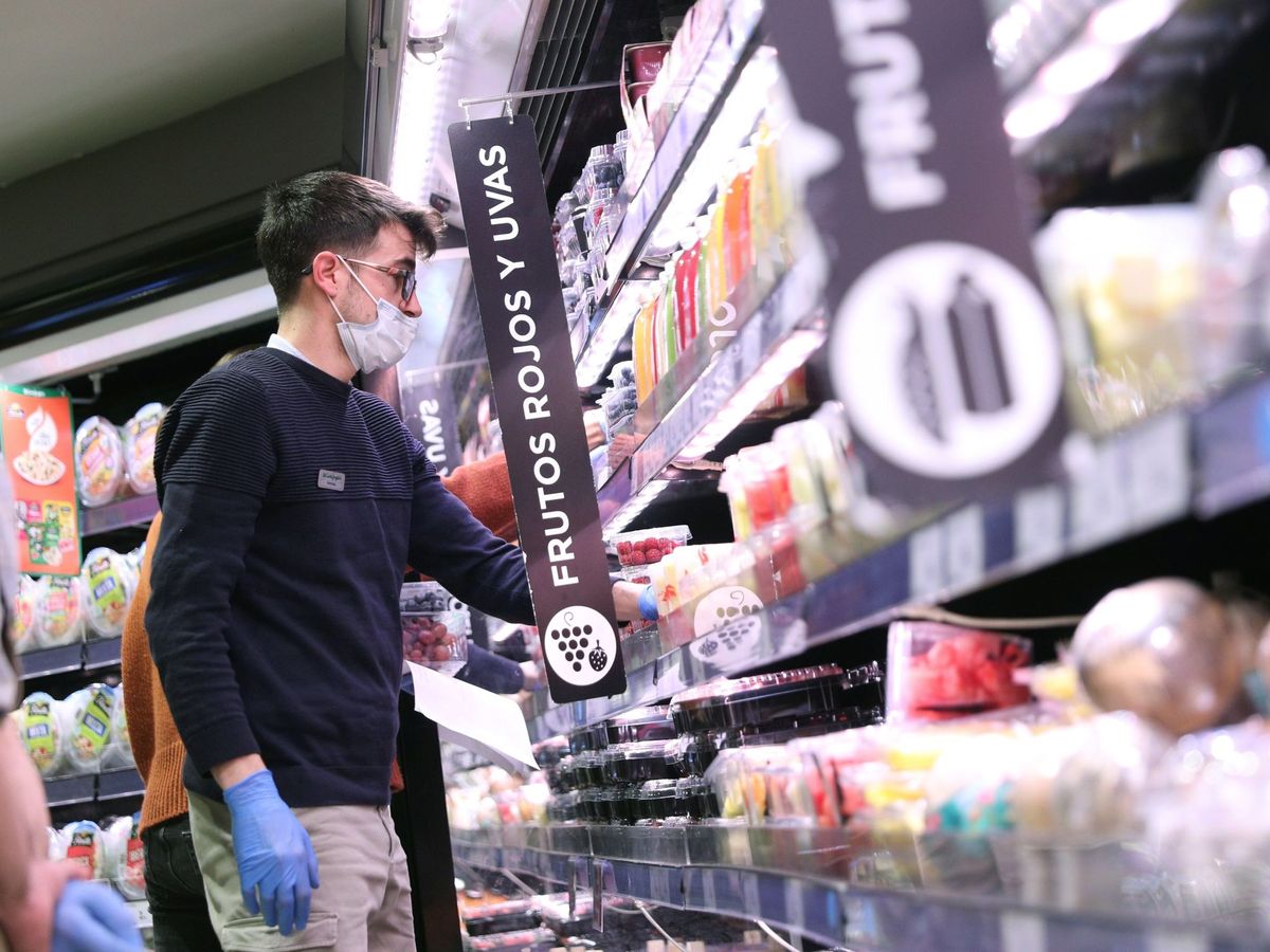 Foto: Varias personas hacen la compra con mascarilla y guantes en un supermercado. (EFE)