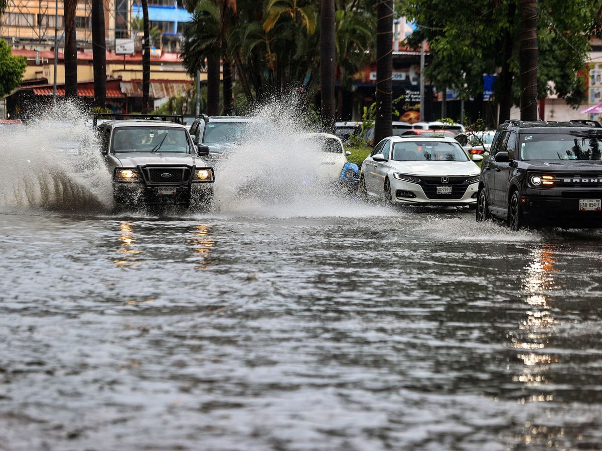 Foto: Vehículos circulan con dificultad tras las fuertes lluvias en una imagen de archivo. (EFE/Daniel Guzmán)