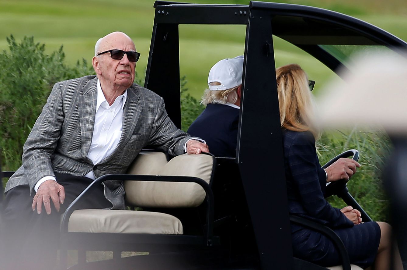 Un día inolvidable: Murdoch en un carrito de golf conducido por Trump con Hall de copiloto. (Reuters)