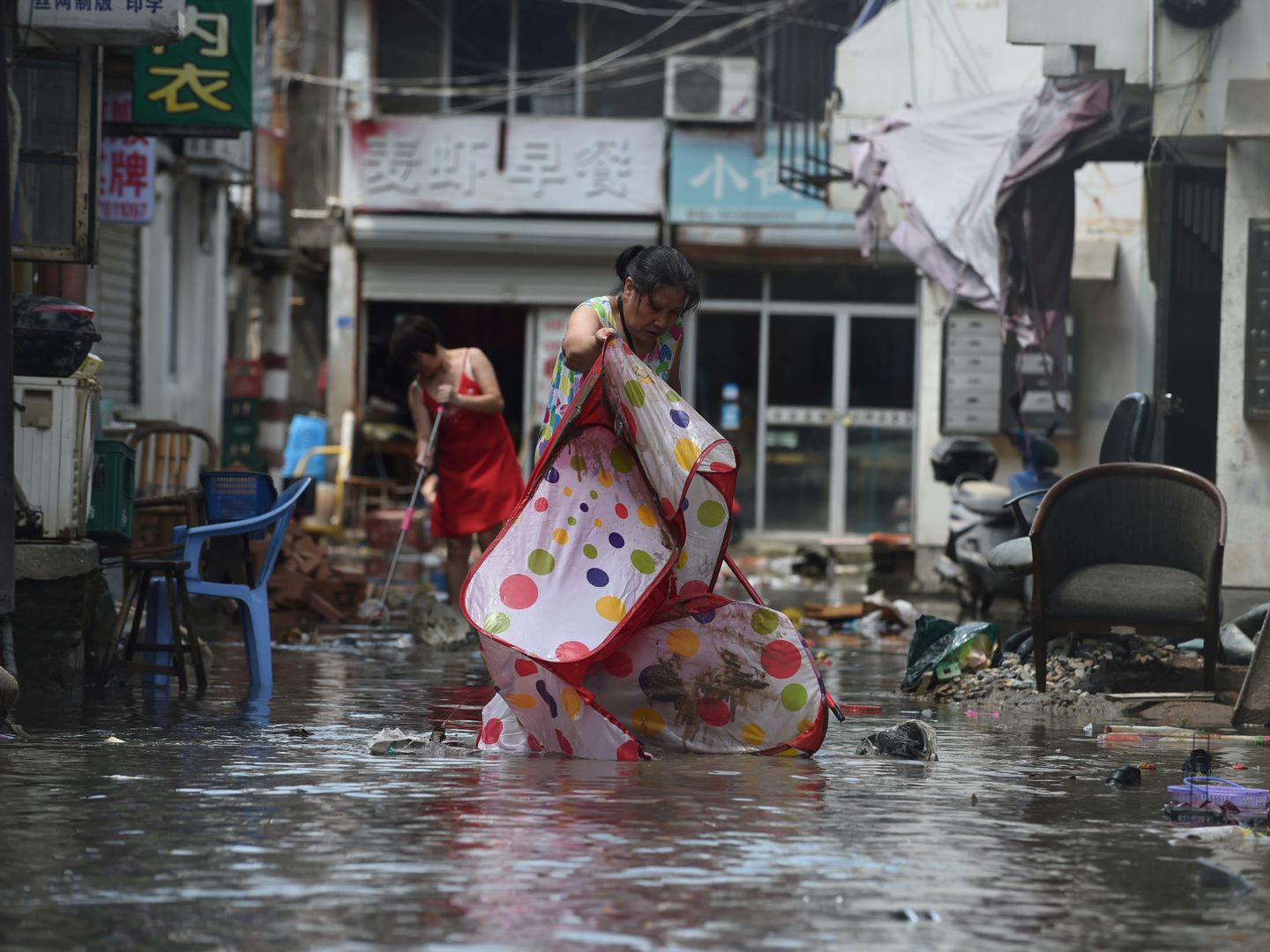 Los ciudadanos achican agua de las calles inundadas por el tifón. (Reuters)