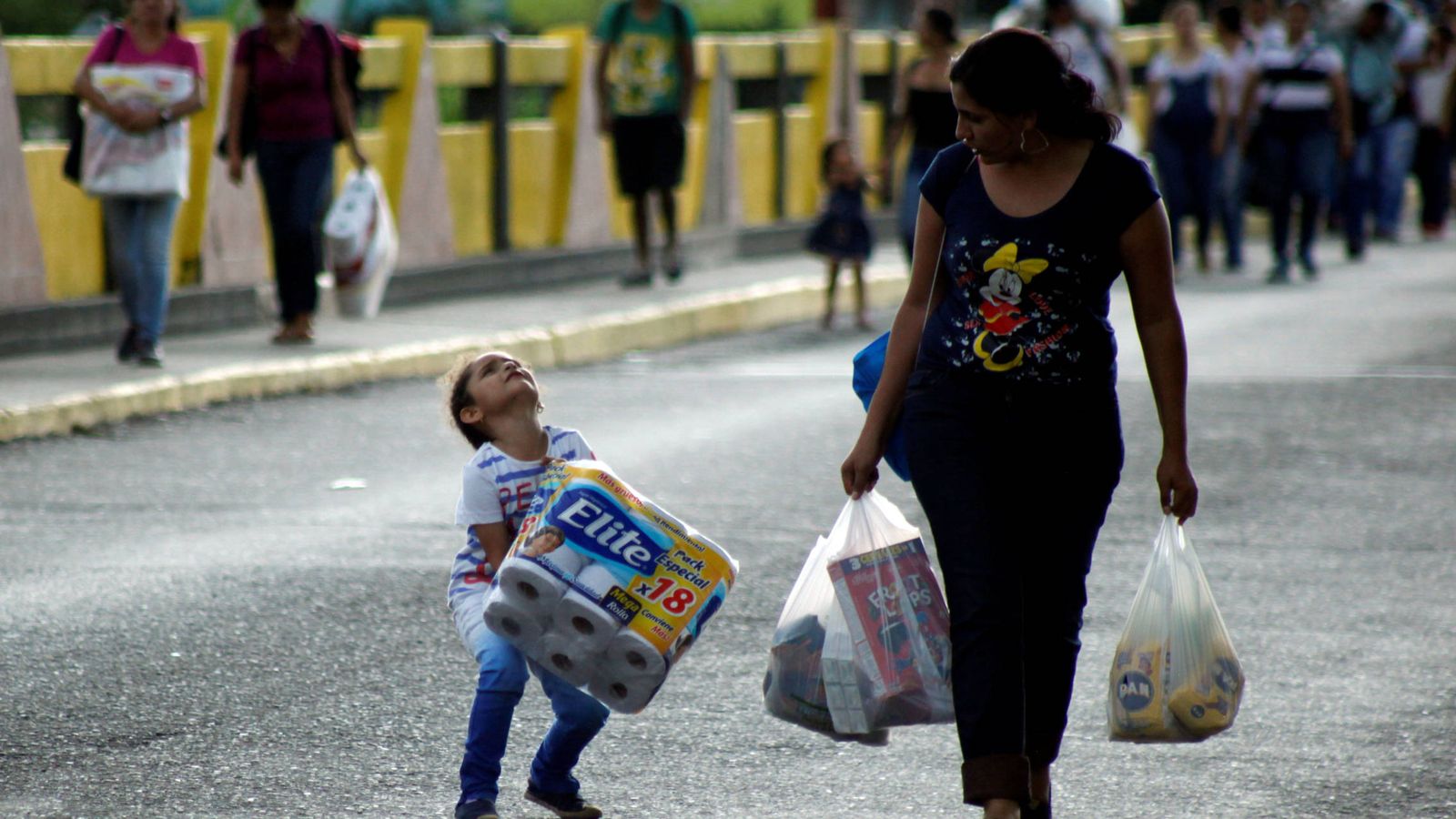 Foto: Un niño venezolano carga con un paquete de papel higiénico al cruza con su madre el Puente Simón Bolívar, que une Venezuela y Colombia (Reuters).