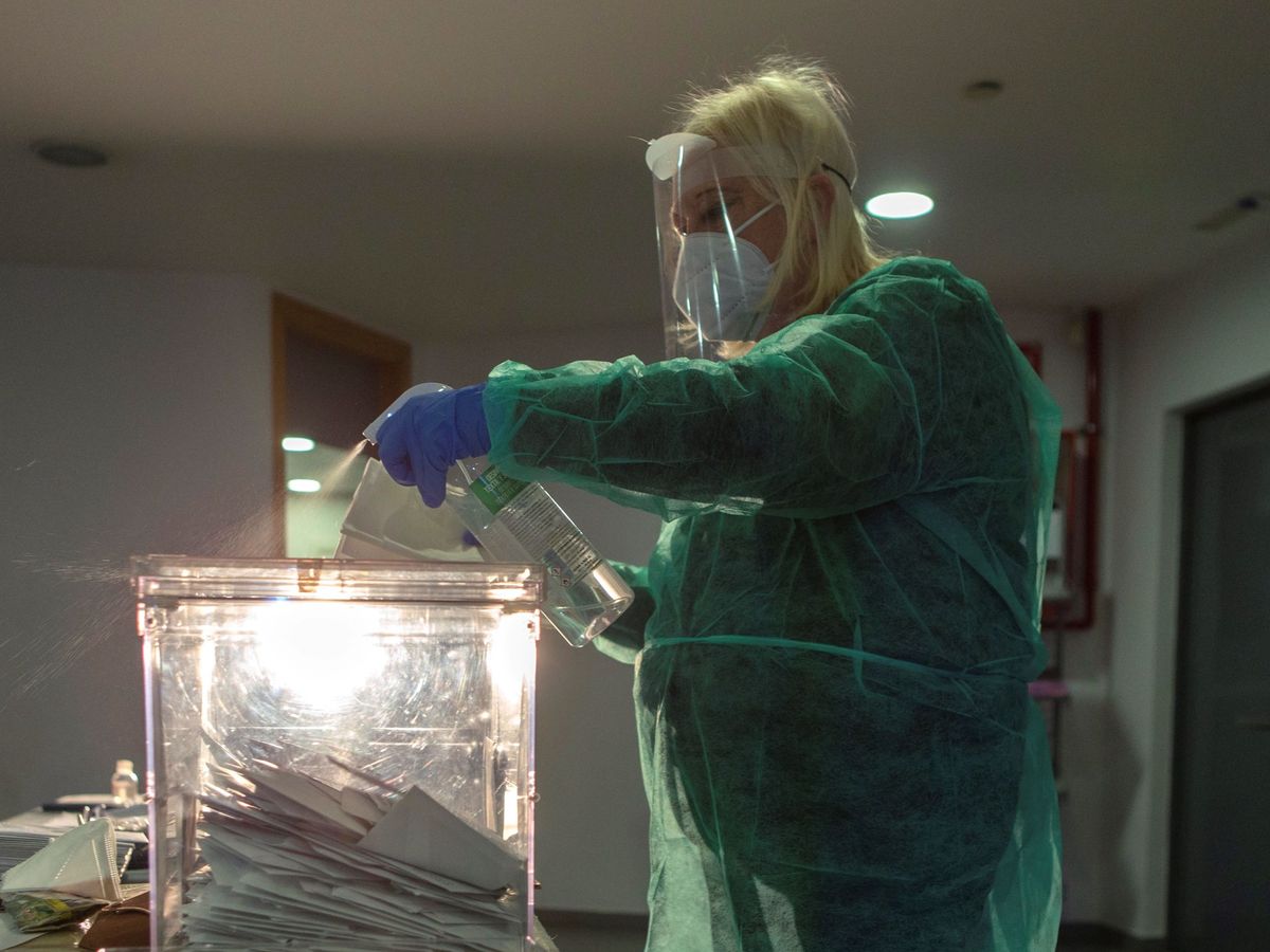 Foto: Un integrante de una mesa electoral de El Masnou, Barcelona, desinfecta una urna (EFE)