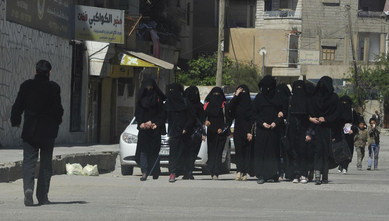 Estudiantes con 'niqab' caminan por una calle de Raqqa, la 'capital' del ISIS en Siria, en marzo de 2014 (Reuters).