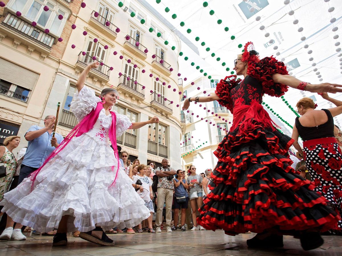 Foto: Mujeres vestidas de flamencas en la calle Larios en 2019. (EFE/EFE Daniel Pérez)