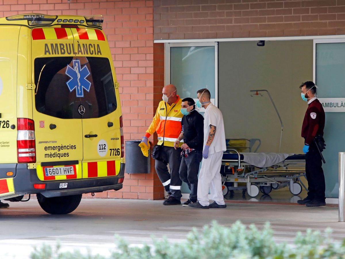 Foto: Personal sanitario acompaña a un enfermo en la puerta del Hospital de Igualada (Barcelona). (EFE)