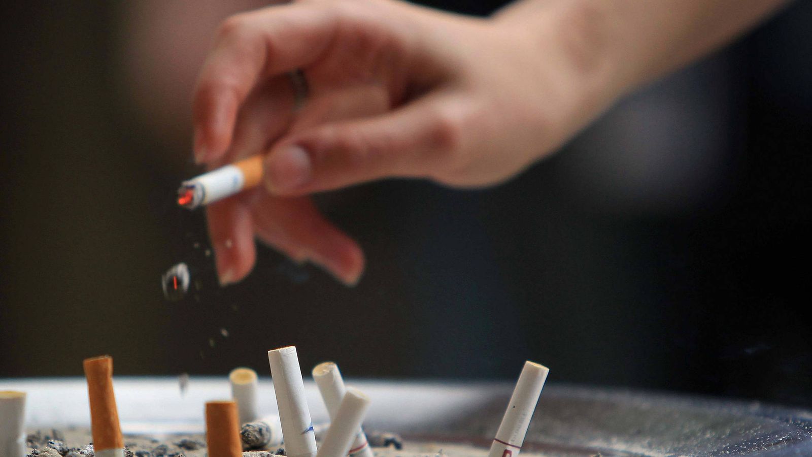 Foto: Una persona echa ceniza junto a colillas de cigarrillo. (Efe)