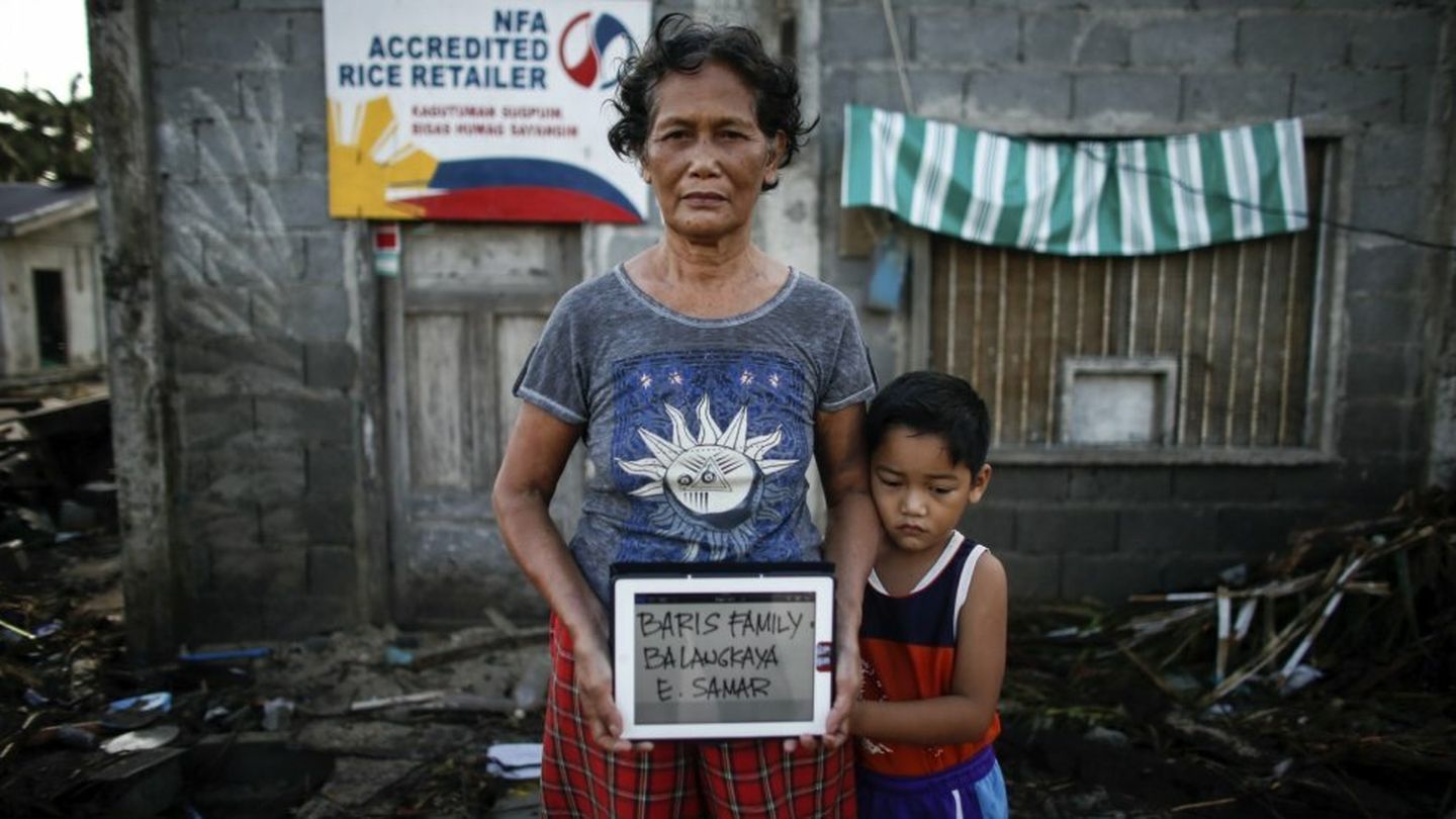 Supervivientes del tifón posan con sus nombres en un cartel en Samar (Reuters)
