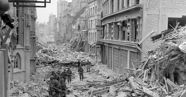 Foto: 07 1944: Las tropas canadienses patrullan a lo largo del destruida Rue Saint-Pierre después de que fuerzas alemanas fueron desalojados de Caen