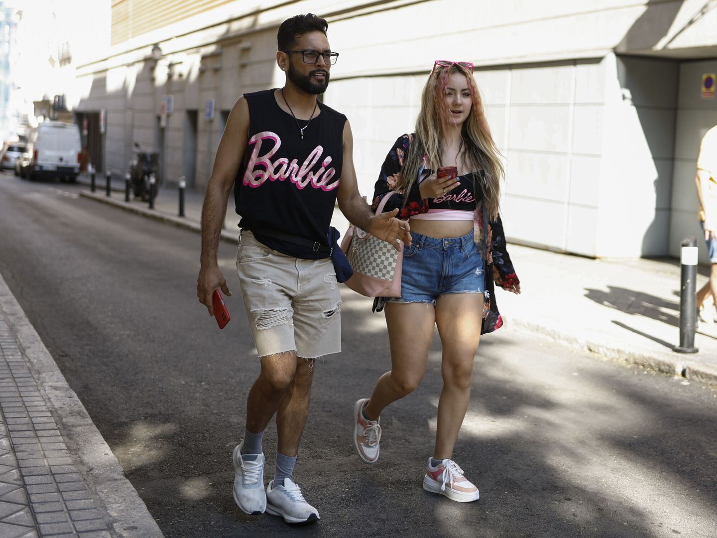 Dos personas lucen atuendos relativos a la película 'Barbie' momentos antes de asistir a la proyección este jueves en Madrid. (EFE/R. Jiménez)
