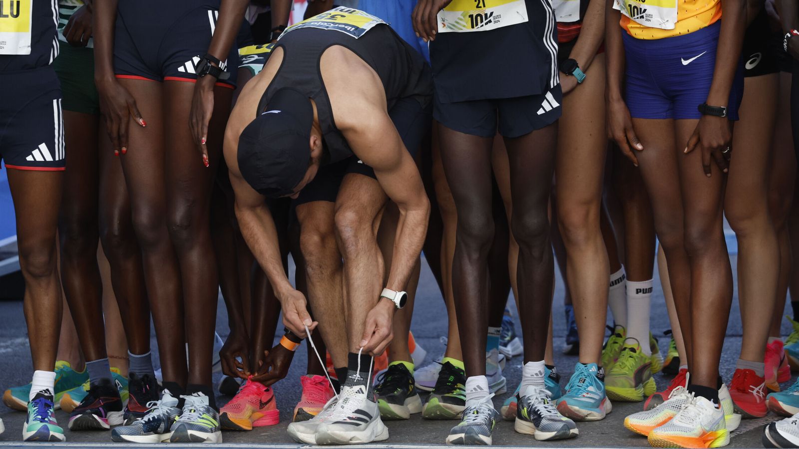 Un atleta se ata la zapatilla antes de la salida del 10K en Valencia. (EFE/Biel Aliño) 
