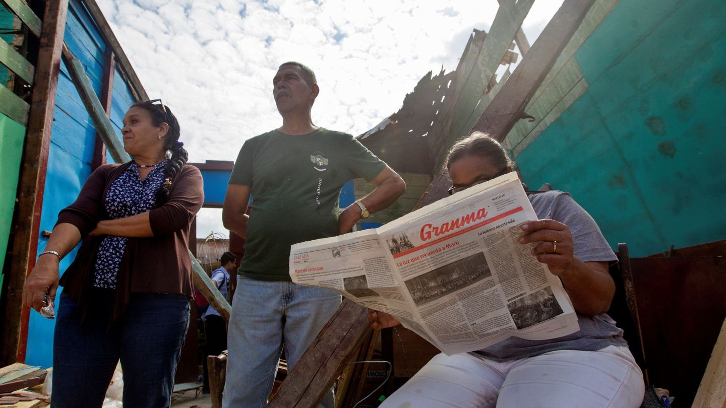 Una mujer lee el periódico 'Granma' tras el paso de un tornado por su casa en La Habana. (EFE)