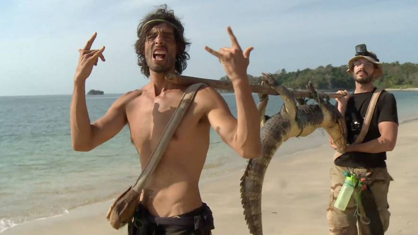 Fernando y David transportando el caimán que cazaron en la isla.
