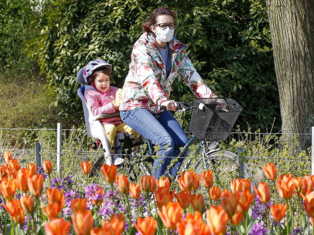 Foto: Una mujer pasea en bicicleta con su hija en Bruselas. EFE