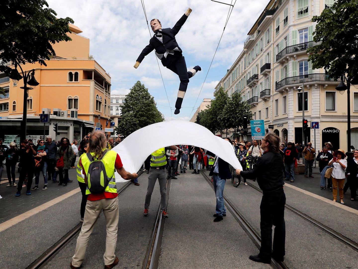 Varias personas lanzan una efigie del presidente francés, Emmanuel Macron, durante una manifestación. (EFE)