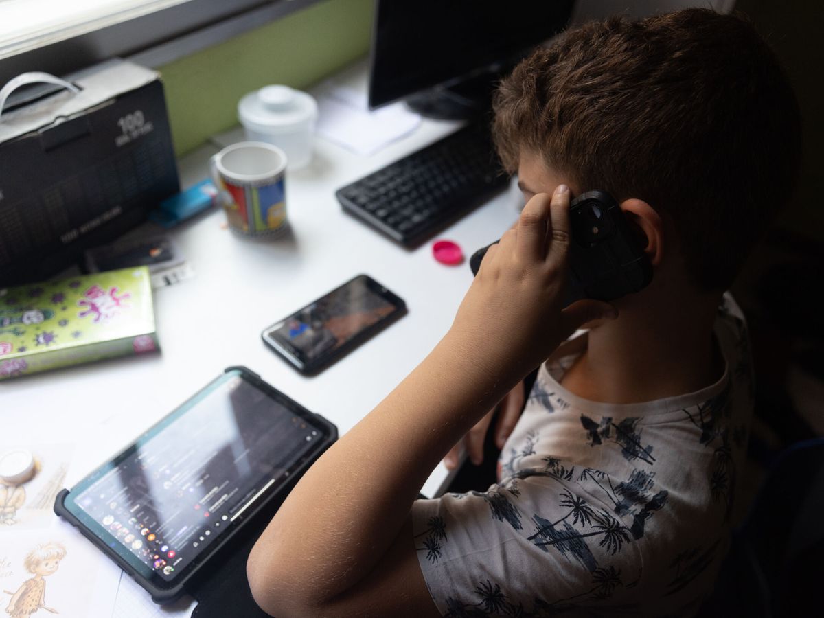 Foto: Un niño usa el teléfono móvil y una tablet en Madrid. (Eduardo Parra/Europa Press)