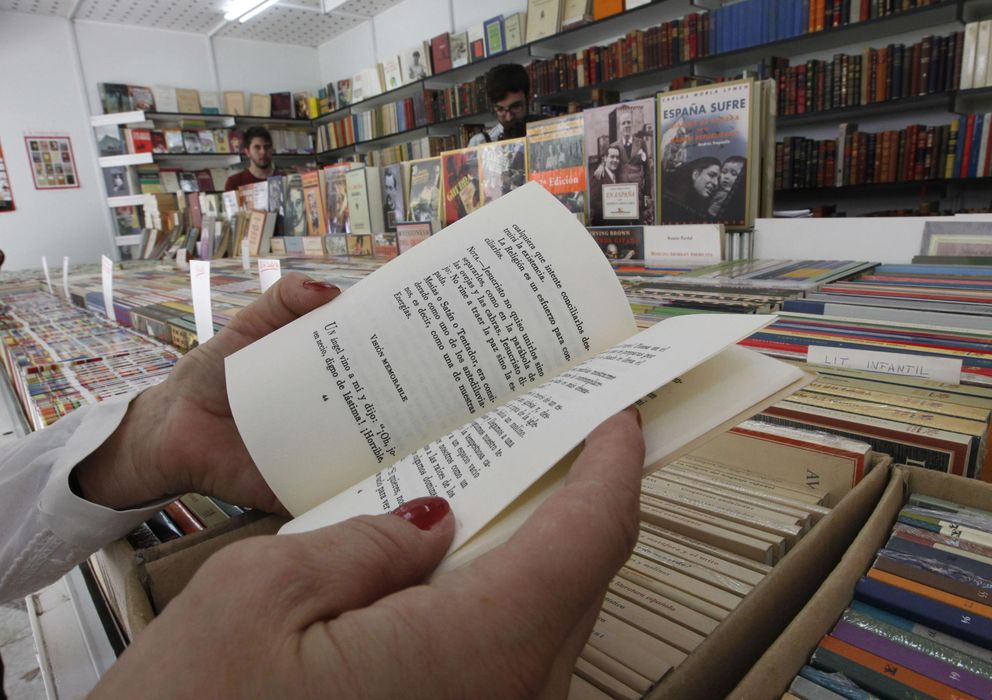 Foto: Una mujer hojea un libro en la 38 Feria del Libro Antiguo y de Ocasión. (EFE)