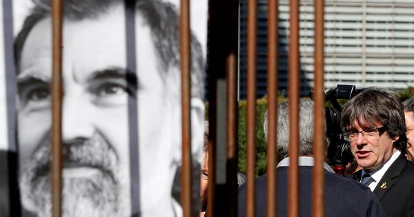 Foto: Carles Puigdemont junto a una pancarta de Jordi Cuixart. (Reuters)