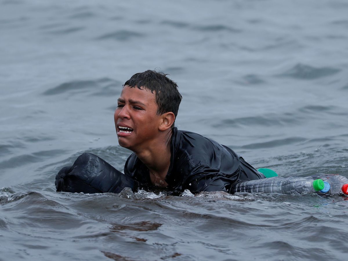 Foto: Un niño marroquí llora mientras nada hacia Ceuta. (Reuters)