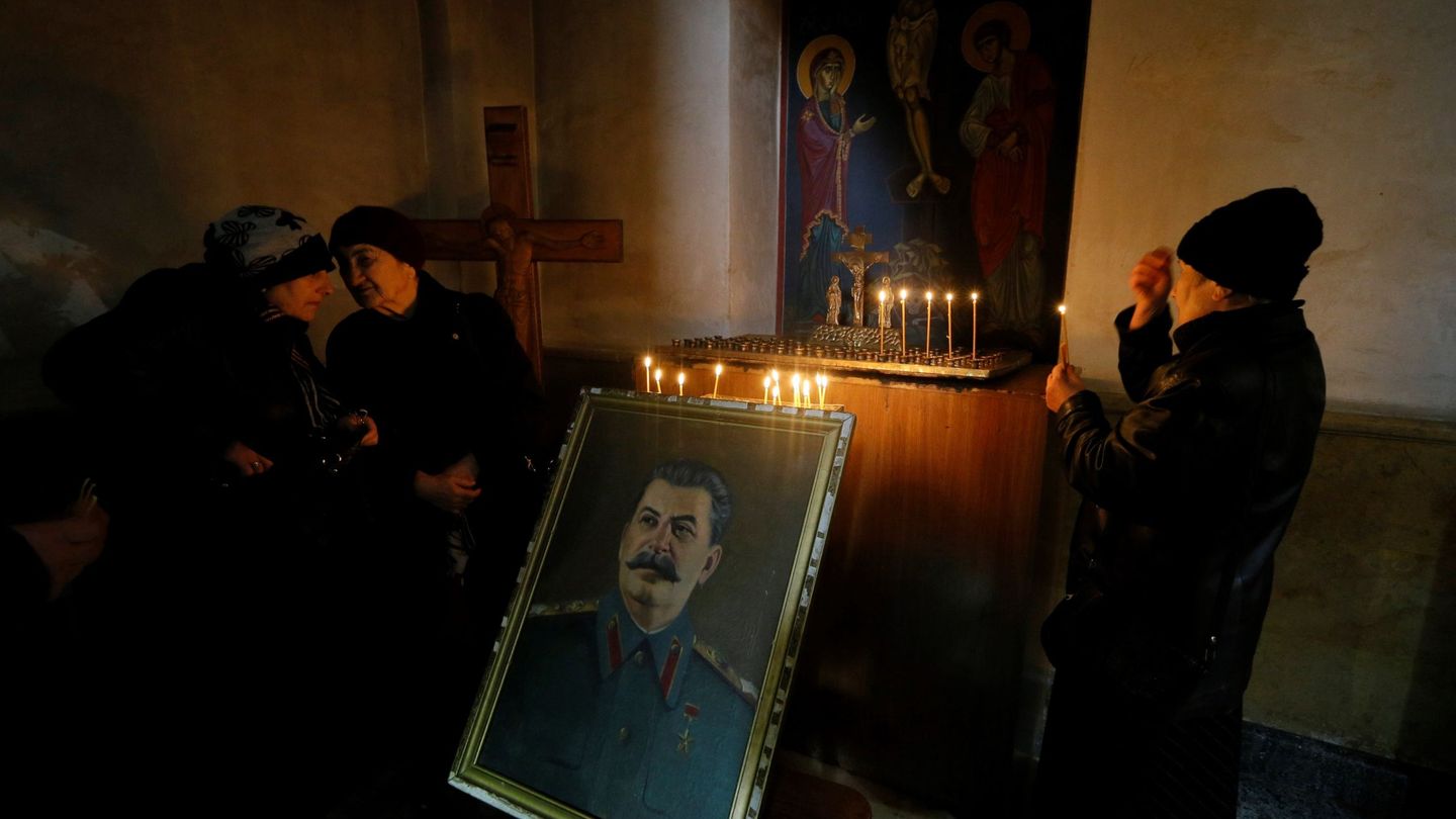 Personas encienden velas junto a un retrato del dictador soviético Iósif Stalin en Gori. (EFE)