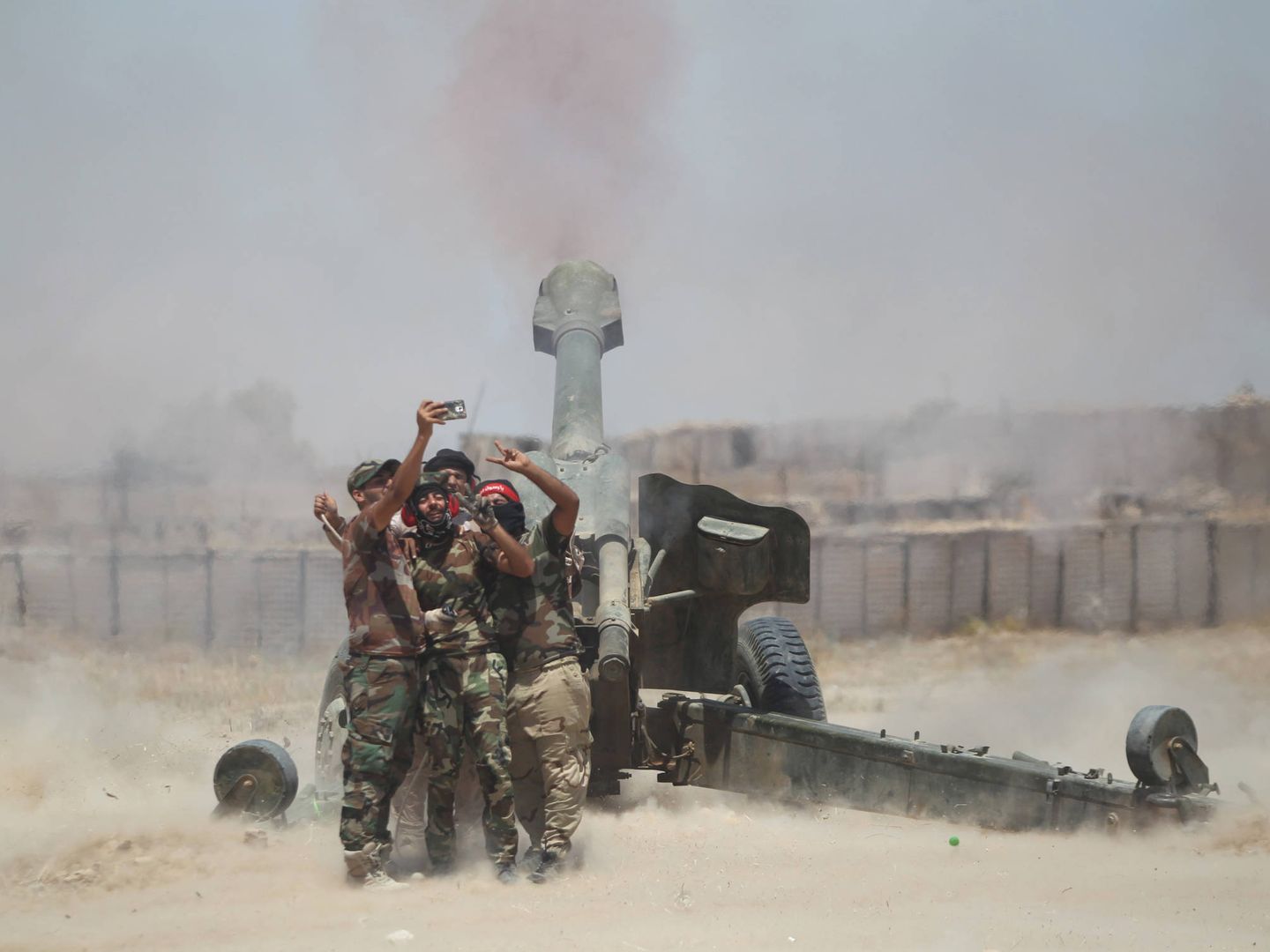Milicianos chiíes se fotografían mientras atacan con artillería posiciones de Daesh en Faluya, Irak. (Reuters)