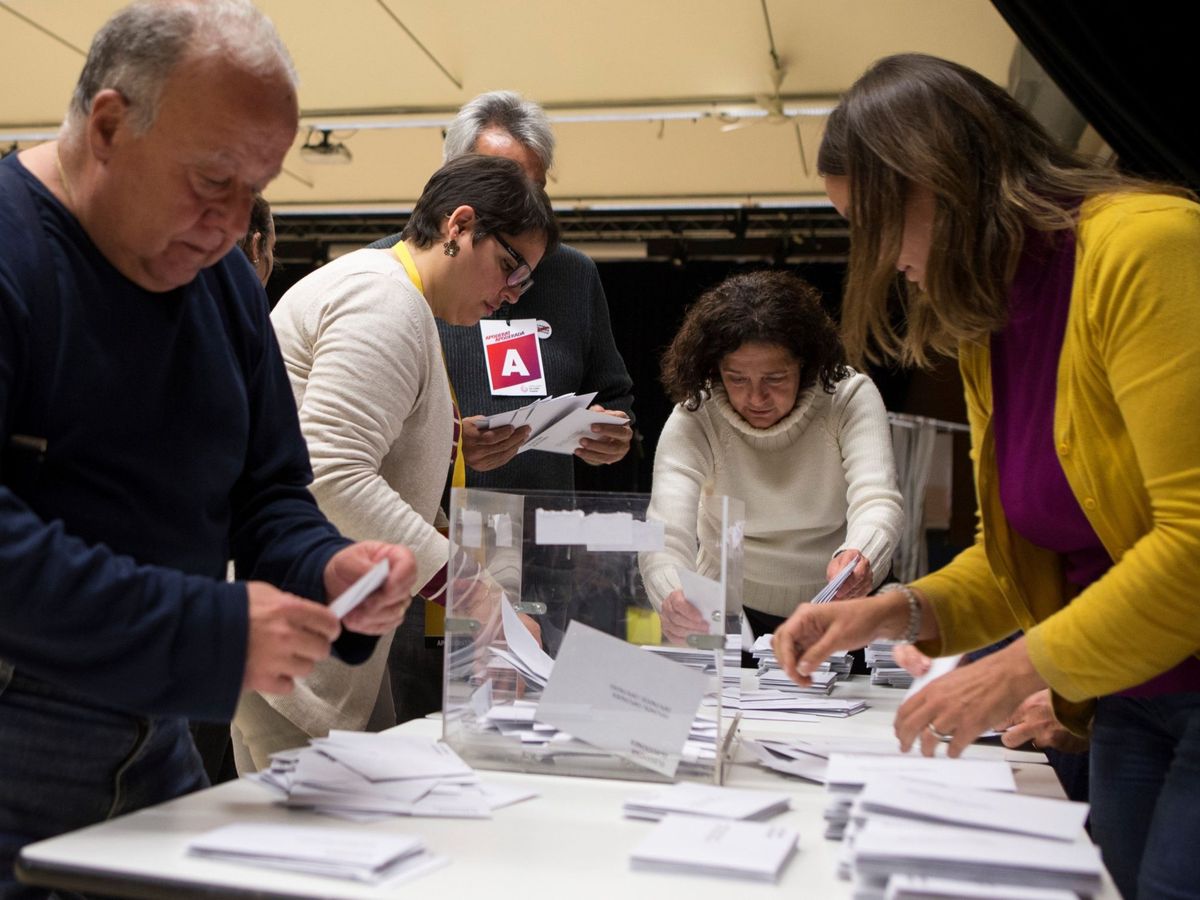 Foto: Los miembros de una mesa electoral participan en el recuento de votos tras la jornada de las elecciones catalanas del 21D. (EFE/Quique García)