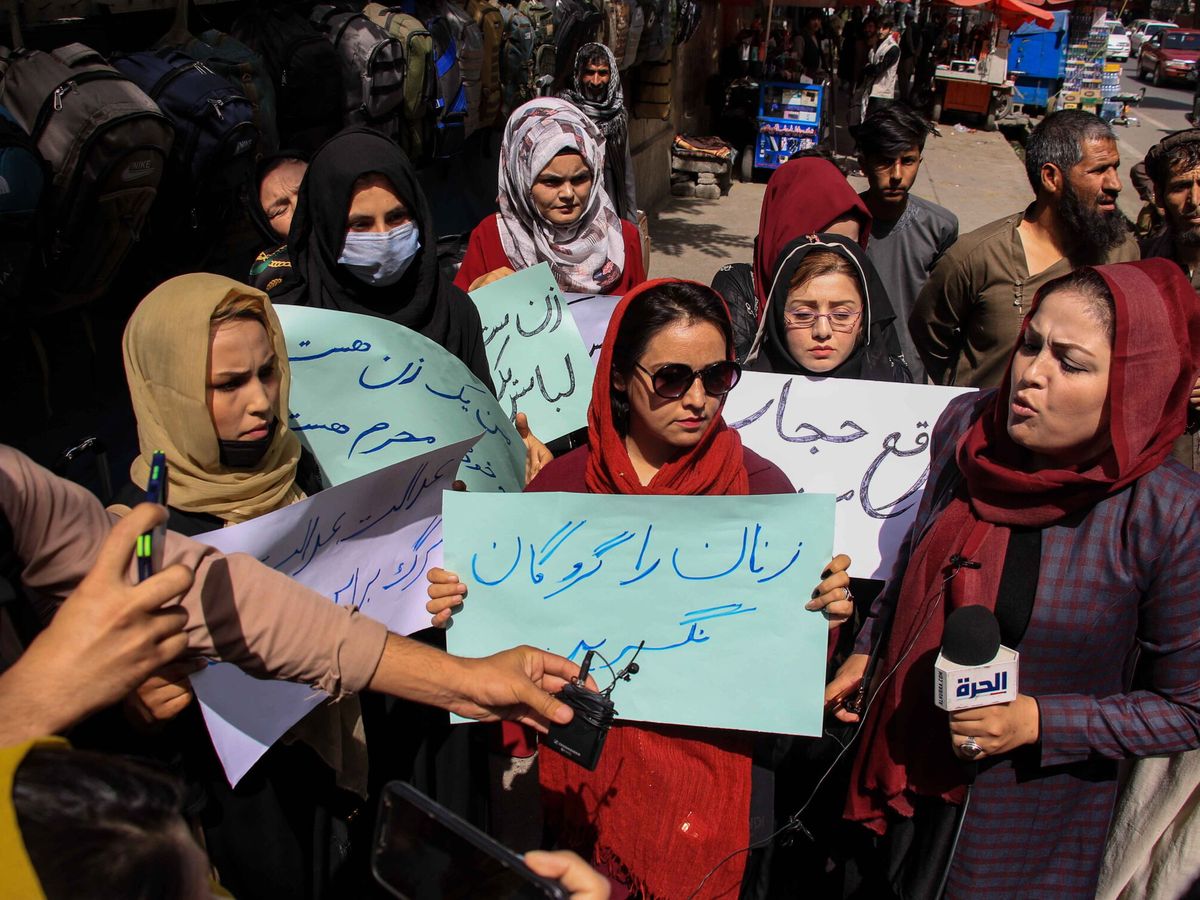 Foto: Protesta de mujeres a cara descubierta en Kabul conta el uso del burka. La pancarta pide 'No tomar a las mujeres como rehenes'. (EFE/Stringer)