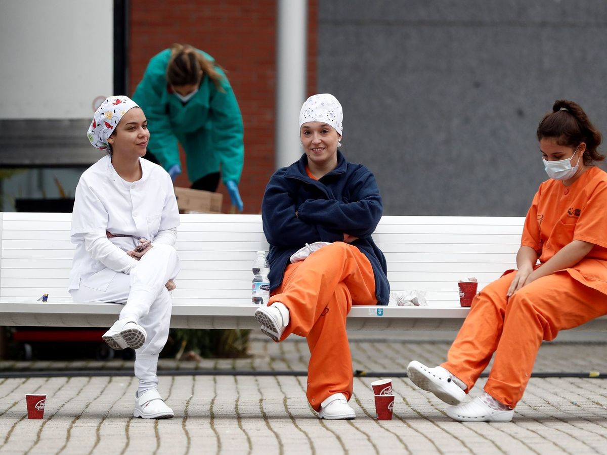 Foto: Varias enfermeras, durante un descanso en las afueras del hospital de campaña de Ifema, en el recinto ferial de Madrid. (EFE)