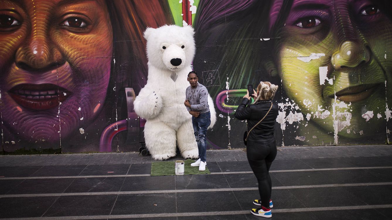 Foto: Un hombre posa con un oso gigante en el graffiti de la Gran Vía. (A. M. Vélez)
