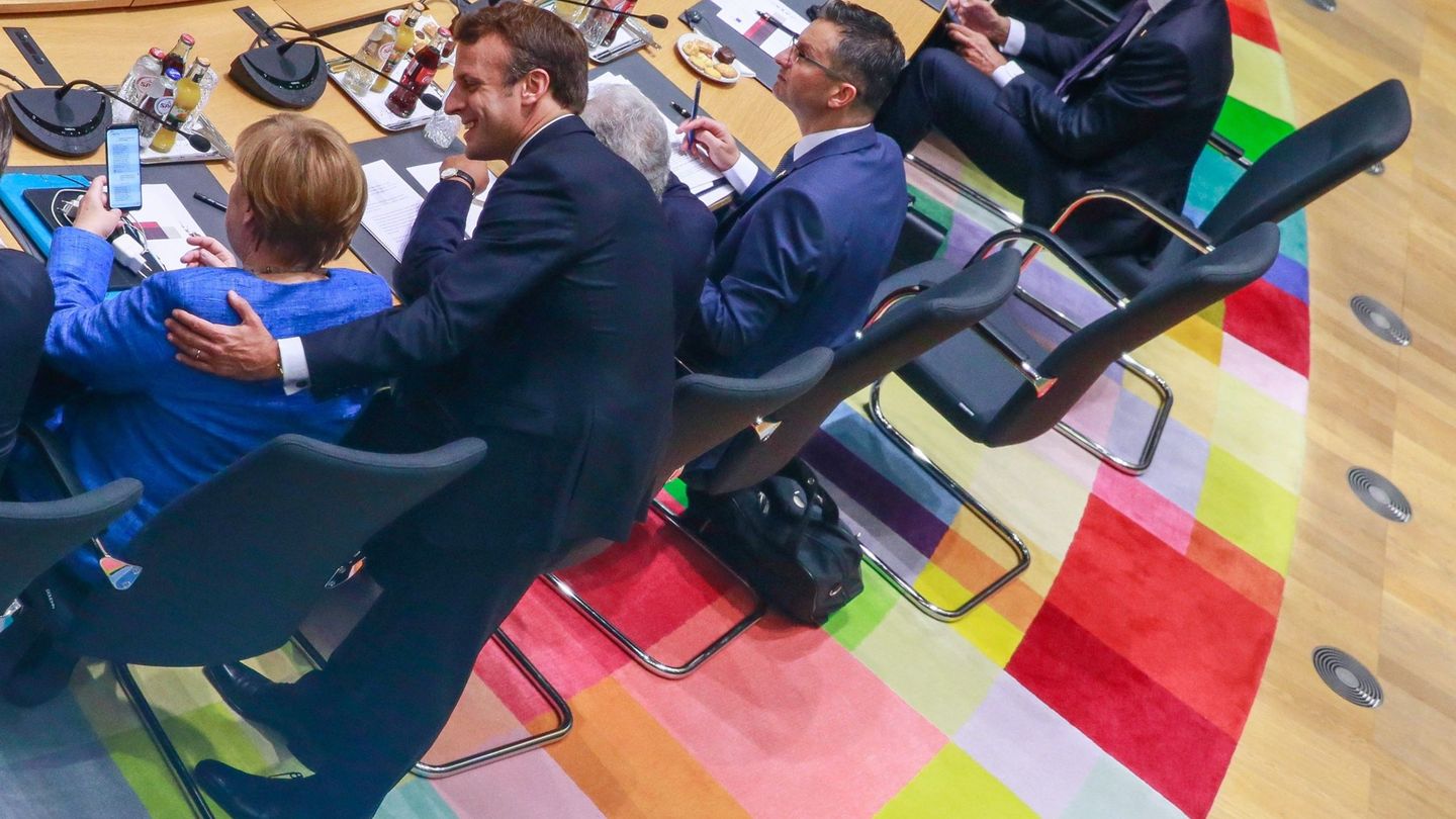 Macron charla con la canciller alemana en el último Consejo Europeo. (EFE)