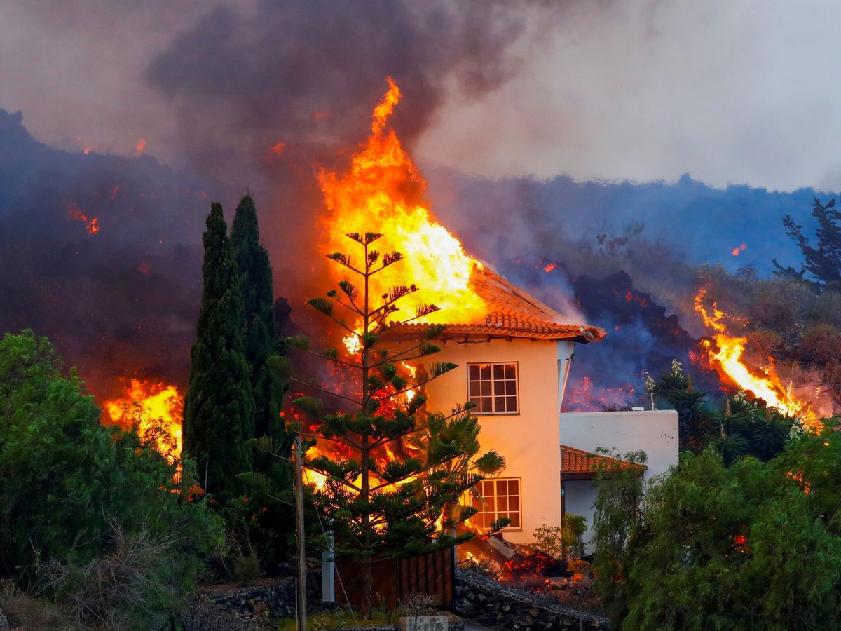 Foto: Una casa arde por la erupción en La Palma. (Reuters)