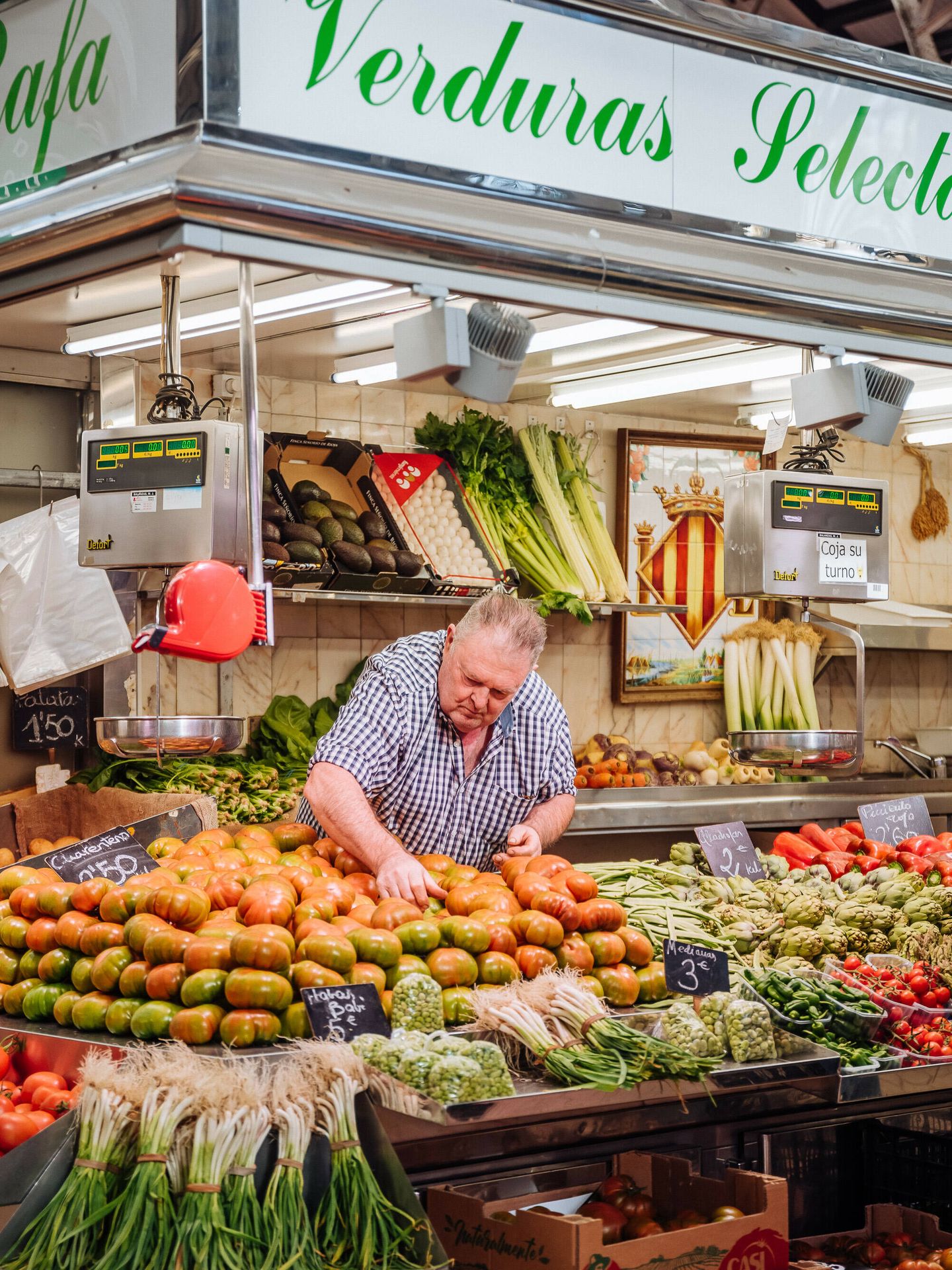 Un hombre en su puesto de verduras del Mercado. (Cedida)
