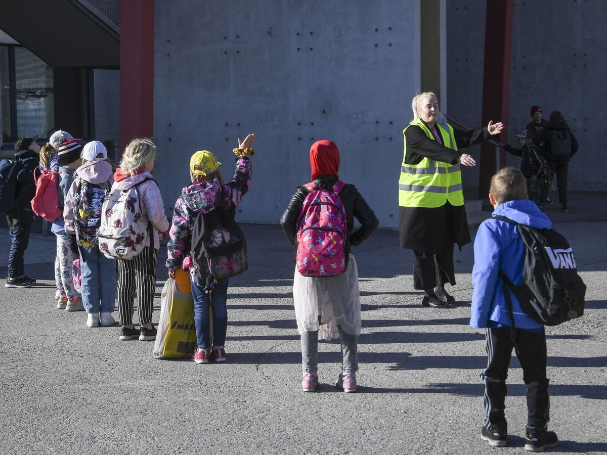 Foto: Un profesor guía a los niños de una escuela de Helsinki. (EFE/Kimmo Brandt)
