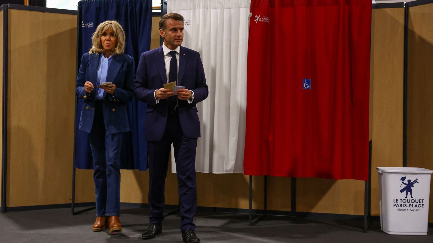 French President Emmanuel Macron and his wife Brigitte Macron walk inside a polling station during the European Parliament election, in Le Touquet-Paris-Plage, France, June 9, 2024. REUTERS Hannah McKay Pool