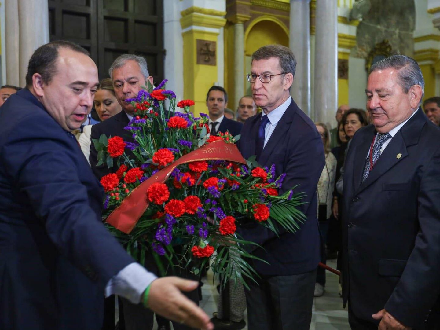 Alberto Núñez Feijóo y José Luis Sanz hacen entrega de una ofrenda floral a la Hermandad de San Benito de Sevilla, en la mañana de este Martes Santo. (Cedida/PP)